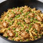 Wok of chicken fried rice with egg, peas, and scallions